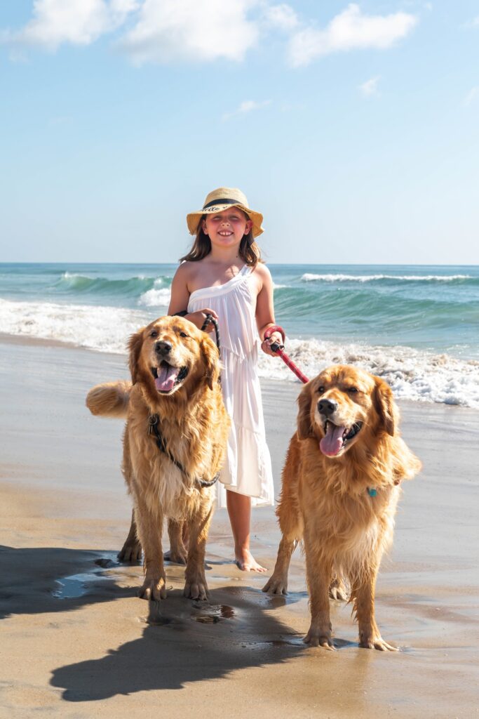 obx family beach photography and weddings mary ks photography obxgirl wearing hat with two dogs on leash on beach obx
