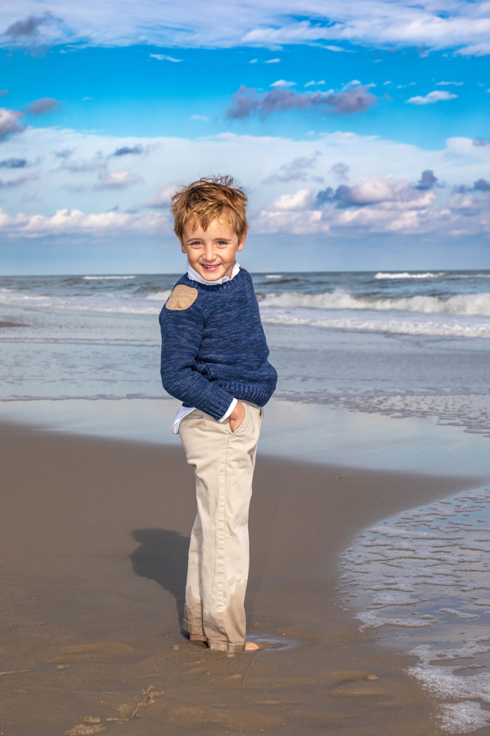 young boy wearing sweater on beach outer banks obx